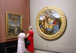Twee dames zijn erg onder de indruk van het schilderij.